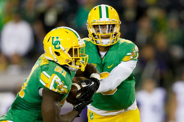 Oregon quarterback Marcus Mariota (8) hands the ball to Oregon running back Royce Freeman (21) during the fourth quarter against Washington in an NCAA college football game in Eugene, Ore., Saturday, Oct. 18, 2014. (AP Photo/Ryan Kang)