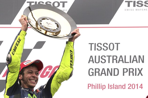 MotoGP rider Valentino Rossi of Italy raises his winners trophy as he celebrates after winning the Australian Motorcycle Grand Prix at Phillip Island, Australia,  Sunday, Oct. 19, 2014. Rossi won the race ahead of Jorge Lorenzo of Spain and Bradley Smith of Britain.(AP Photo/Rob Griffith)
