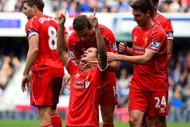 LONDON, ENGLAND - OCTOBER 19:  Philippe Coutinho of Liverpool celebrates with team-mates after scoring his team's ssecond goal during the Barclays Premier League match between Queens Park Rangers and Liverpool at Loftus Road on October 19, 2014 in London, England.  (Photo by Paul Gilham/Getty Images)