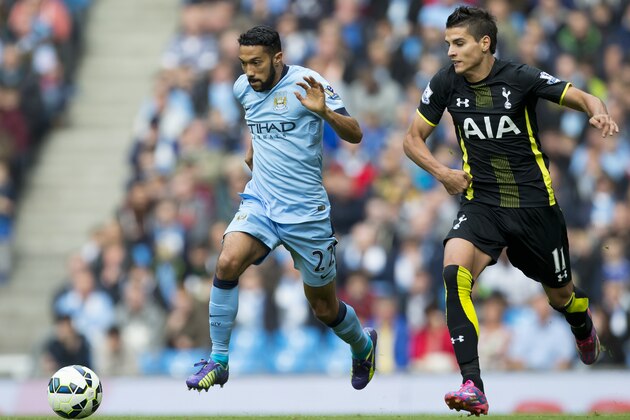 Manchester City's Gael Clichy, center, fights for the ball against Tottenham's Erik Lamela during the English Premier soccer match between Manchester City and Tottenham Hotspur at the Etihad Stadium, Manchester, England, Saturday Oct. 18, 2014. (AP Photo/Jon Super)