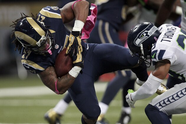 St. Louis Rams running back Tre Mason, left, slips past Seattle Seahawks free safety Earl Thomas on his way to a 6-yard touchdown run during the first quarter of an NFL football game Sunday, Oct. 19, 2014, in St. Louis. (AP Photo/Tom Gannam)