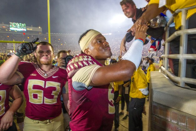 Florida State quarterback Jameis Winston, right, and Larry Levy celebrate after defeating Notre Dame 31-27 in an NCAA college football game in Tallahassee, Fla., Saturday, Oct. 18, 2014. Florida State defeated Notre Dame 31-27.  (AP Photo/Mark Wallheiser)