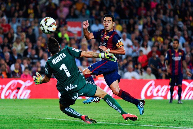 BARCELONA, SPAIN - OCTOBER 18:  Xavi Hernandez of FC Barcelona scores the opening goal past Xabi Irureta of SD Eibar during the La Liga match between FC Barcelona and SD Eibar at Camp Nou on October 18, 2014 in Barcelona, Spain.  (Photo by Sandra Montanez/Getty Images)