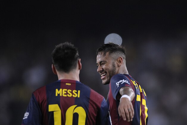 FC Barcelona's Lionel Messi, from Argentina, left, is congratulated after scoring by his teammate Neymar, from Brazil, right, during a Spanish La Liga soccer match at the Camp Nou stadium against Eibar in Barcelona, Spain, Saturday, Oct. 18, 2014. (AP Photo/Manu Fernandez)