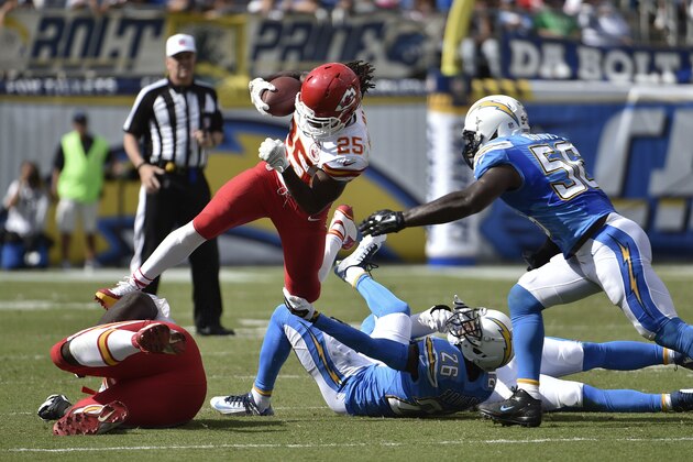 Kansas City Chiefs running back Jamaal Charles leaps over San Diego Chargers cornerback Brandon Flowers (26) and inside linebacker Andrew Gachkar, right, during the first half of an NFL football game Sunday, Oct. 19, 2014, in San Diego. (AP Photo/Denis Poroy)