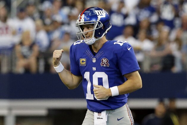 New York Giants quarterback Eli Manning celebrates a touchdown against the Dallas Cowboys during the first half of an NFL football game, Sunday, Oct. 19, 2014, in Arlington, Texas. (AP Photo/LM Otero)