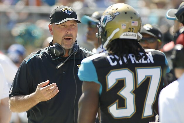 Jacksonville Jaguars head coach Gus Bradley, left, talks with strong safety Johnathan Cyprien (37) on the sidelines during the first half of an NFL football game against the Cleveland Browns in Jacksonville, Fla., Sunday, Oct. 19, 2014. (AP Photo/Stephen B. Morton)
