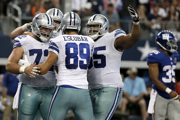 Dallas Cowboys' Gavin Escobar (89) is congratulated on his touchdown by Travis Frederick (72), Zack Martin, center rear, and Ronald Leary (65) as New York Giants free safety Quintin Demps (35) walks back to the sideline during the second half of an NFL football game, Sunday, Oct.  19, 2014, in Arlington, Texas. (AP Photo/Brandon Wade)