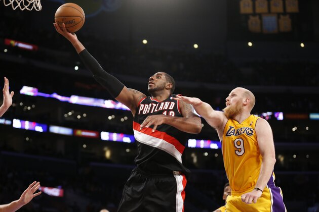 Portland Trail Blazers forward LaMarcus Aldridge, left, goes to the hoop in front of Los Angeles Lakers center Chris Kaman, right, during the second half of an NBA basketball game in Los Angeles, Tuesday, April 1, 2014. The Trail Blazers won 124-112. (AP Photo/Danny Moloshok)