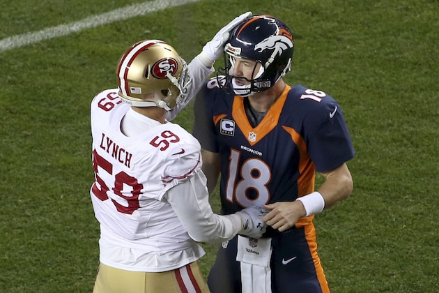 Denver Broncos quarterback Peyton Manning (18) is congratulated by San Francisco 49ers linebacker Aaron Lynch (59) after Manning threw his 507th career touchdown pass, the first of the game, during the first half of an NFL football game, Sunday, Oct. 19, 2014, in Denver.  (AP Photo/David Zalubowski)