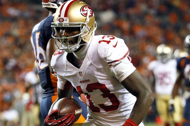 San Francisco 49ers wide receiver Stevie Johnson (13) scores a touchdown against the Denver Broncos during the first half of an NFL football game, Sunday, Oct. 19, 2014, in Denver. (AP Photo/Jack Dempsey)