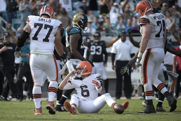Cleveland Browns quarterback Brian Hoyer (6) reacts after getting sacked by defensive end Chris Clemons as guard John Greco (77) and tackle Paul McQuistan (74) come to help him up during the second half of an NFL football game in Jacksonville, Fla., Sunday, Oct. 19, 2014.(AP Photo/Phelan M. Ebenhack)