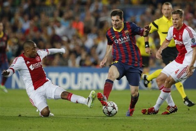 Ajax players Stefano Denswil, left, and Ajax's Christian Poulsen, right, try and stop Barcelona's Lionel Messi, center, during the Champions League group H soccer match between Ajax Amsterdam and F.C. Barcelona on Wednesday, Sept. 18, 2013, at Camp Nou stadium in Barcelona, Spain. (AP Photo/Emilio Morenatti)