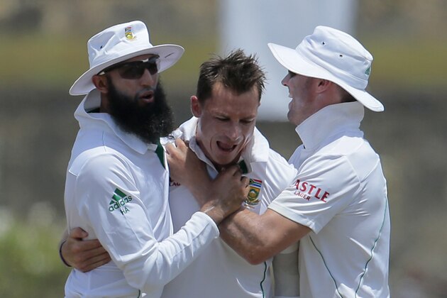 South African test cricket captain Hashim Amla, left, and AB de Villiers, right, congratulate bowler Dale Steyn for the dismissal of Sri Lankan batsman Dilruwan Perera during the fifth day of the first test cricket match in Galle, Sri Lanka, Sunday, July 20, 2014. (AP Photo/Eranga Jayawardena)