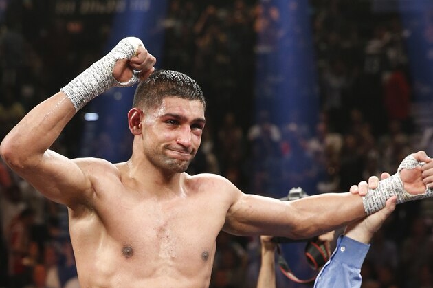 England's Amir Khan celebrates his unanimous decision over Luis Collazo in their silver welterweight title boxing fight Saturday, May 3, 2014, in Las Vegas. (AP Photo/Eric Jamison)