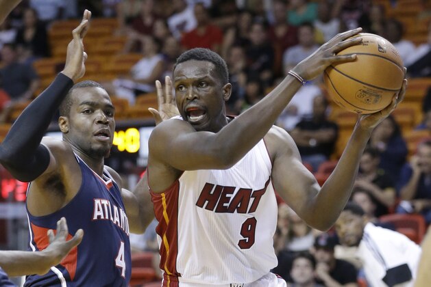 Miami Heat forward Luol Deng (9) of Sudan, looks for an opening past Atlanta Hawks forward Paul Millsap (4) during the second half of a preseason NBA basketball game, Tuesday, Oct. 14, 2014 in Miami. The Hawks defeated the Heat 109-103. (AP Photo/Wilfredo Lee)