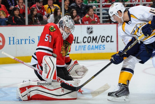 CHICAGO, IL - OCTOBER 18:  Goalie Corey Crawford #50 of the Chicago Blackhawks deflects the puck as Craig Smith #15 of the Nashville Predators approaches during the NHL game on October 18, 2014 at the United Center in Chicago, Illinois. (Photo by Bill Smith/NHLI via Getty Images)