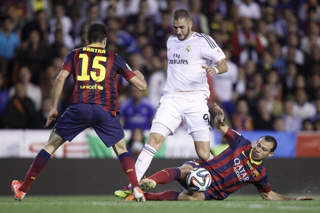 Barcelona's Javier Mascherano, right, shields the the ball from Real's Karim Benzema, centre  during the final of the Copa del Rey between FC Barcelona and Real Madrid at the Mestalla stadium in Valencia, Spain, Wednesday, April 16, 2014. (AP Photo/Alberto Saiz)
