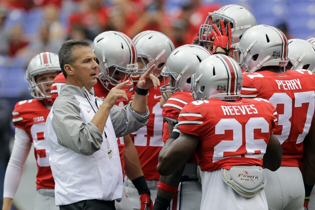Ohio State head coach Urban Meyer, left, gathers with his players before an NCAA college football game against Navy in Baltimore, Saturday, Aug. 30, 2014. (AP Photo/Patrick Semansky)