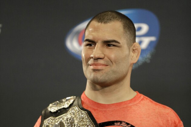 UFC heavyweight champion Cain Velasquez poses with his championship belt following a media availability Thursday, Oct. 17, 2013, in Houston. Velasquez will face former UFC heavyweight champion Junior Dos Santos in a rematch in Houston Saturday. He beat Santos in a five-round decision in December to regain the title after Santos won in a knockout in the first meeting in 2011. (AP Photo/Pat Sullivan)