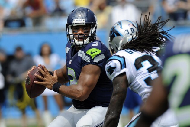 Sep 8, 2013; Charlotte, NC, USA; Seattle Seahawks quarterback Russell Wilson (3) is pursued by Carolina Panthers safety Charles Godfrey (30) for a sack during the game at Bank of America Stadium. Mandatory Credit: Sam Sharpe-USA TODAY Sports
