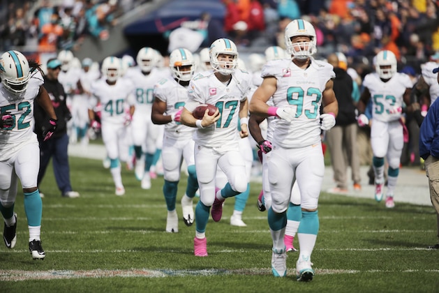 Miami Dolphins linebacker Jason Trusnik (93) and quarterback Ryan Tannehill (17) lead players onto the field before their NFL football game against the Chicago Bears Sunday, Oct. 19, 2014 in Chicago. (AP Photo/Charles Rex Arbogast)