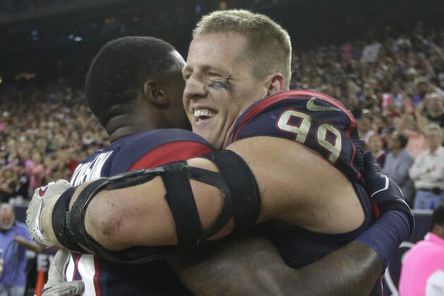 Houston Texans defensive end J.J. Watt (99) is congratulated by wide receiver Andre Johnson (80) after returning a fumble 45 yards for a touchdown during the second half of an NFL football game, Thursday, Oct. 9, 2014, in Houston. (AP Photo/Patric Schneider)