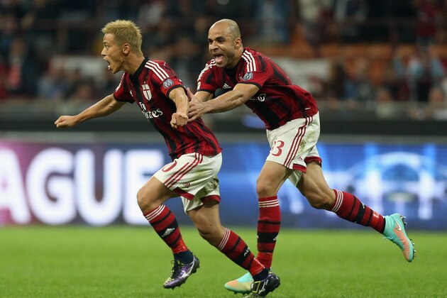 MILAN, ITALY - OCTOBER 04:  Keisuke Honda (L) of Milan celebrates after scoring the second goal with his team-mate Alex during the Serie A match between AC Milan and AC Chievo Verona at Stadio Giuseppe Meazza on October 4, 2014 in Milan, Italy.  (Photo by Maurizio Lagana/Getty Images)
