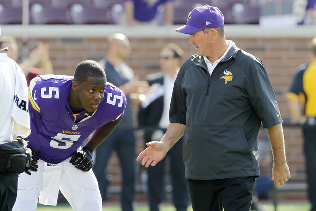 Minnesota Vikings head coach Mike Zimmer, right, talks with  quarterback Teddy Bridgewater (5) before an NFL football game against the Atlanta Falcons, Sunday, Sept. 28, 2014, in Minneapolis. (AP Photo/Ann Heisenfelt)
