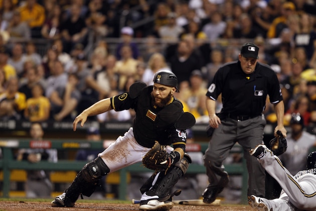 PITTSBURGH, PA - SEPTEMBER 20:  Russell Martin #55 of the Pittsburgh Pirates fields the throw to home plate after Elian Herrera #3 of the Milwaukee Brewers scores on a sacrifice fly by Logan Schafer #1 (not pictured)  during the nnth inning as home plate umpire Marty Foster watches on September 20, 2014 at PNC Park in Pittsburgh, Pennsylvania.  The Brewers defeated the Pirates 1-0.  (Photo by David Maxwell/Getty Images)