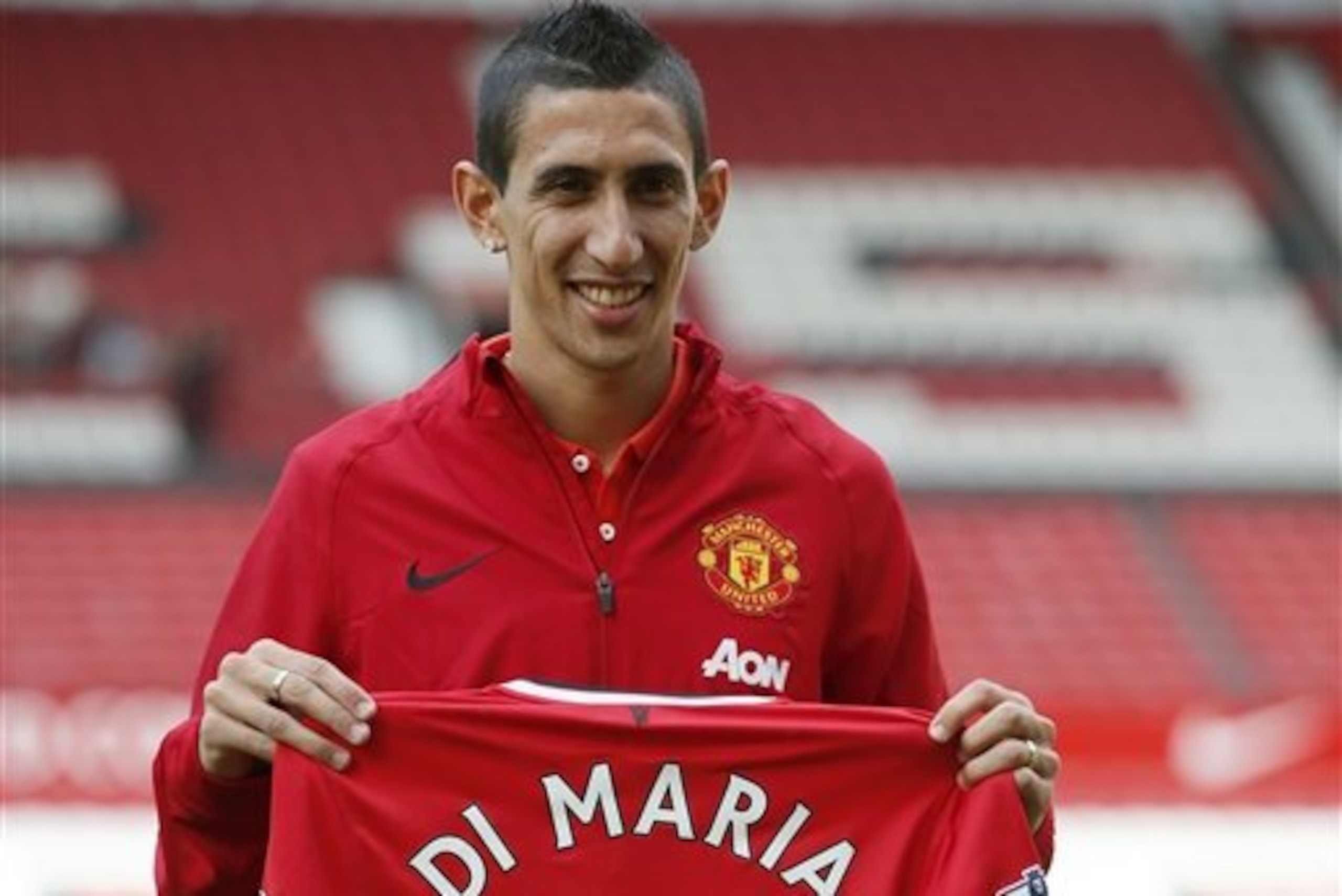 Manchester United's new player Angel Di Maria poses for photographers holding his new shirt, at Old Trafford Stadium in Manchester, England, Thursday, Aug. 28, 2014. Manchester United have signed winger Angel Di Maria from Real Madrid for a British record transfer fee of £59.7m. The Argentine winger had a medical in Manchester on Tuesday and has signed a five-year deal. (AP Photo/Alastair Grant) Manchester United's new player Angel Di Maria poses for photographers holding his new shirt, at Old Trafford Stadium in Manchester, England, Thursday, Aug. 28, 2014. Manchester United have signed winger Angel Di Maria from Real Madrid for a British record transfer fee of £59.7m. The Argentine winger had a medical in Manchester on Tuesday and has signed a five-year deal. (AP Photo/Alastair Grant)