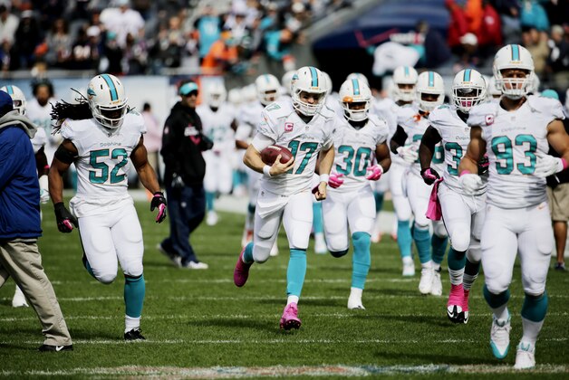 Miami Dolphins quarterback Ryan Tannehill (17) leads his team onto he field before their NFL football game against the Chicago Bears Sunday, Oct. 19, 2014 in Chicago. (AP Photo/Charles Rex Arbogast)