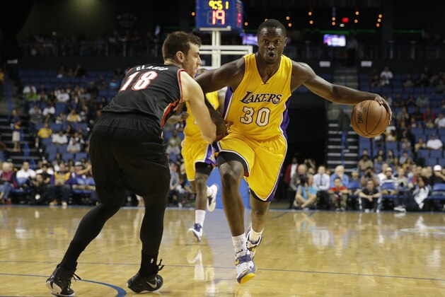 Los Angeles Lakers' Julius Randle, right, drives on Portland Trail Blazers' Victor Claver during the first half of a preseason NBA basketball game Wednesday, Oct. 22, 2014, in Ontario, Calif. (AP Photo/Jae C. Hong)