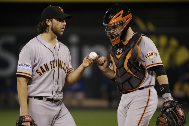 San Francisco Giants pitcher Madison Bumgarner, left, talks with catcher Buster Posey during the second inning of Game 1 of baseball's World Series against the Kansas City Royals Tuesday, Oct. 21, 2014, in Kansas City, Mo. (AP Photo/Matt Slocum )