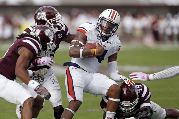 Auburn quarterback Nick Marshall (14) is tackled by several Mississippi State defenders including defensive back Jamerson Love (5) and linebacker Christian Holmes in the first half of their NCAA college football game in Starkville, Miss., Saturday, Oct 11, 2014. No. 3 Mississippi State beat No. 2 Auburn 38-23. (AP Photo/Rogelio V. Solis)