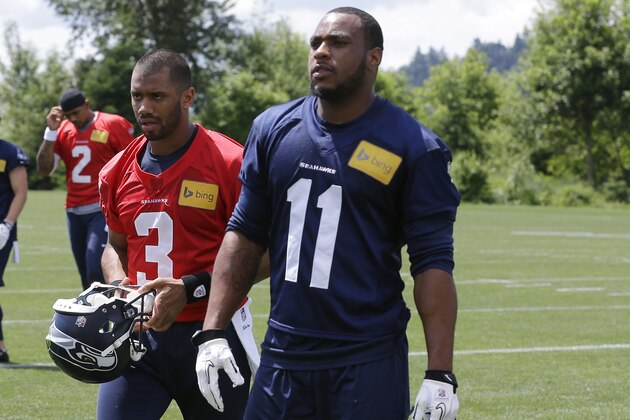 Seattle Seahawks quarterback Russell Wilson (3) and wide receiver Percy Harvin (11) walk off the field following an NFL football organized team activity, Tuesday, May 27, 2014, in Renton, Wash. (AP Photo/Ted S. Warren)