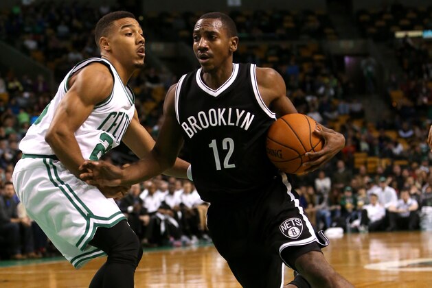 BOSTON, MA - OCTOBER 22: Marquis Teague #12 of the Brooklyn Nets drives to the basket against Phil Pressey #26 of the Boston Celtics in the second half during a preseason game at TD Garden on October 22, 2014 in Boston, Massachusetts. NOTE TO USER: User expressly acknowledges and agrees that, by downloading and or using this photograph, User is consenting to the terms and conditions of the Getty Images License Agreement.  (Photo by Mike Lawrie/Getty Images)