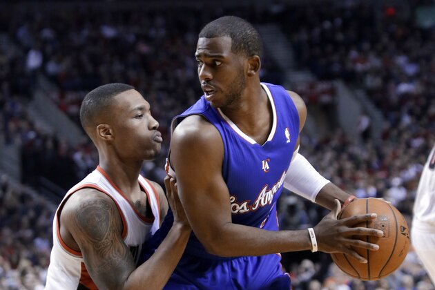 Los Angeles Clippers guard Chris Paul, right, looks for room to move against tight defense by Portland Trail Blazers guard Damian Lillard during the first half of an NBA basketball game in Portland, Ore., Thursday, Dec. 26, 2013. (AP Photo/Don Ryan)