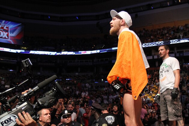 Conor McGregor, of Ireland, leaves the ring draped in an Irish flag after beathing Max Holloway in their UFC on Fox Sports 1 mixed martial arts bout in Boston, Saturday, August 17,2013. McGregor won via unanimous decision. (AP Photo/Gregory Payan)