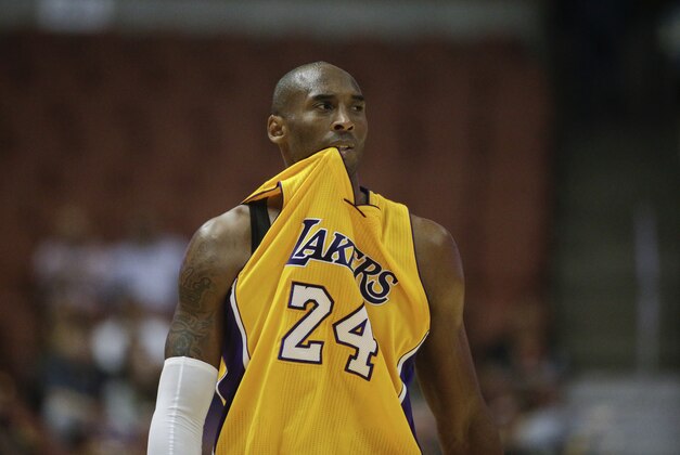 Los Angeles Lakers' Kobe Bryant bites his jersey during the first half of a preseason NBA basketball game against the Phoenix Suns on Tuesday, Oct. 21, 2014, in Anaheim, Calif. (AP Photo/Jae C. Hong)