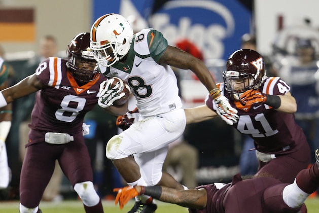 Miami running back Duke Johnson (8) breaks a tackle by Virginia Tech linebacker Andrew Motuapuaka, bottom right, linebacker Derek Di Nardo (41) and  safety Detrick Bonner (8) during the first half of an NCAA college football game at Scott Stadium in Blacksburg, Va., Thursday, Oct. 23, 2014. (AP Photo/Steve Helber)