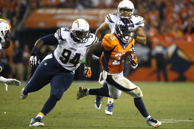 Denver Broncos running back Ronnie Hillman (23) eludes the grasp of San Diego Chargers defensive end Corey Liuget (94) during the first half of an NFL football game, Thursday, Oct. 23, 2014, in Denver. (AP Photo/Jack Dempsey)
