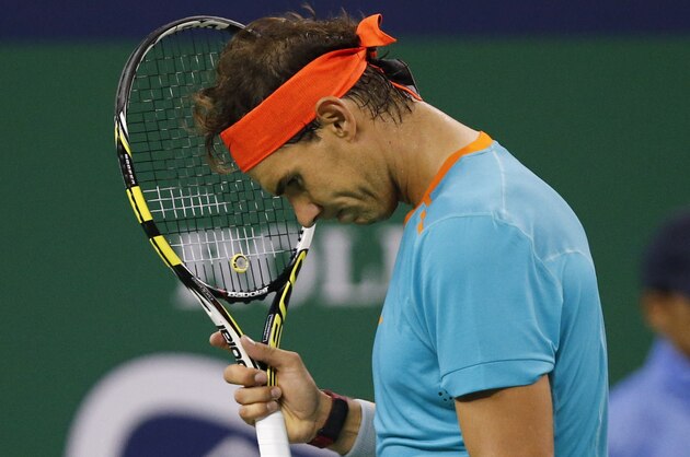 Rafael Nadal of Spain places his head on his racquet after missing a point during the men's singles second round match against Feliciano Lopez of Spain at the Shanghai Masters Tennis Tournament in Shanghai, China, Wednesday, Oct. 8, 2014.  (AP Photo/Vincent Thian)