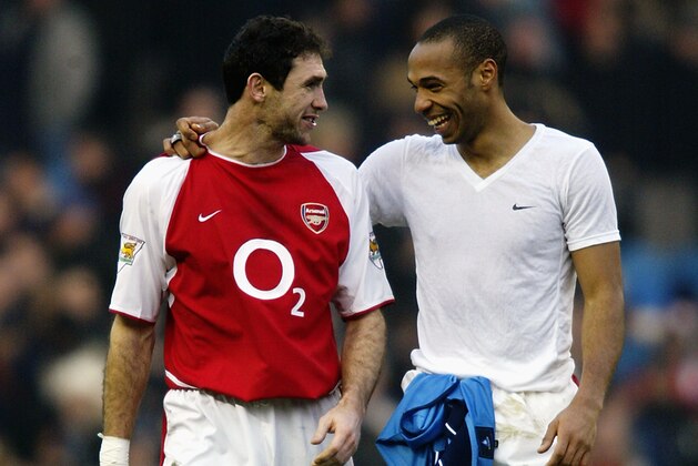 MANCHESTER - FEBRUARY 22:  Arsenal team-mates Martin Keown (left) and Thierry Henry (right) share a joke as they celebrate a easy victory to keep them leading the way at the top of the league after the FA Barclaycard Premiership match between Manchester City and Arsenal held on February 22, 2003 at Maine Road, in Manchester, England. Arsenal won the match 5-1. (Photo by Gary M. Prior/Getty Images)