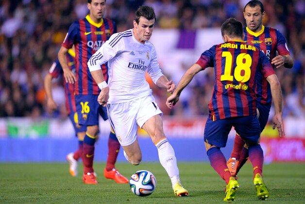 Real's Gareth Bale, center, drives the ball past Barcelona's Jordi Alba during the final of the Copa del Rey between FC Barcelona and Real Madrid at the Mestalla stadium in Valencia, Spain, Wednesday, April 16, 2014. (AP Photo/Manu Fernandez)
