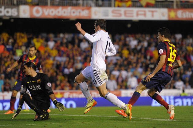 VALENCIA, SPAIN - APRIL 16:  Gareth Bale (C) of Real Madrid beats Marc Bartra (R) and Jose Pinto of Barcelona to score Real's 2nd goal during the  Copa del Rey Final between Real Madrid and Barcelona at Estadio Mestalla on April 16, 2014 in Valencia, Spain.  (Photo by Denis Doyle/Getty Images)