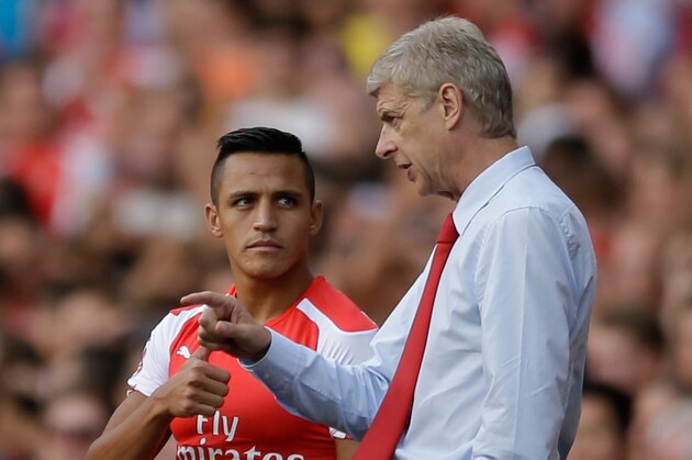 Arsenal's French manager Arsene Wenger, right, gives instructions to his new signing Alexis Sanchez as he substituted on to make his debut, during the Emirates Cup soccer match between between Arsenal and Benfica at Arsenal's Emirates Stadium in London, Saturday, Aug. 2, 2014.  (AP Photo/Matt Dunham)