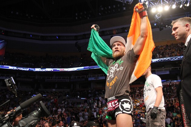 Conor McGregor, of Ireland, leaves the ring draped in an Irish flag after beathing Max Holloway in their UFC on Fox Sports 1 mixed martial arts bout in Boston, Saturday, August 17,2013. McGregor won via unanimous decision. (AP Photo/Gregory Payan)