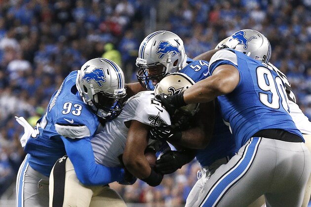 Detroit Lions defensive end George Johnson (93), linebacker DeAndre Levy (54) and defensive tackle Ndamukong Suh (90) stop New Orleans Saints running back Mark Ingram (22) during a NFL football game in Detroit Sunday, Oct. 19, 2014. (AP Photo/Paul Sancya)