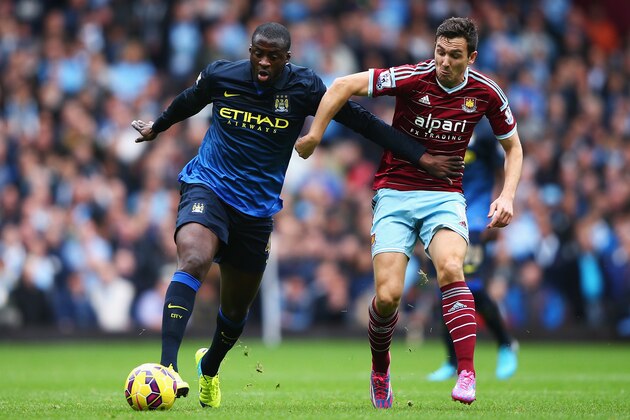 LONDON, ENGLAND - OCTOBER 25:  Yaya Toure of Manchester City is tackled by Stewart Downing of West Ham United during the Barclays Premier League match between West Ham United and Manchester City at Boleyn Ground on October 25, 2014 in London, England.  (Photo by Ian Walton/Getty Images)